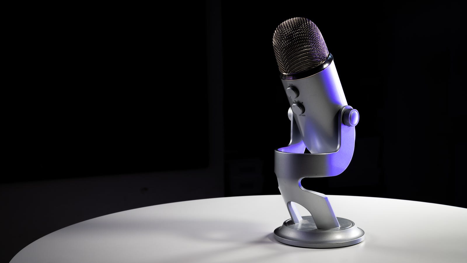 Blue Yeti microphone sur une table argentée sur fond noir