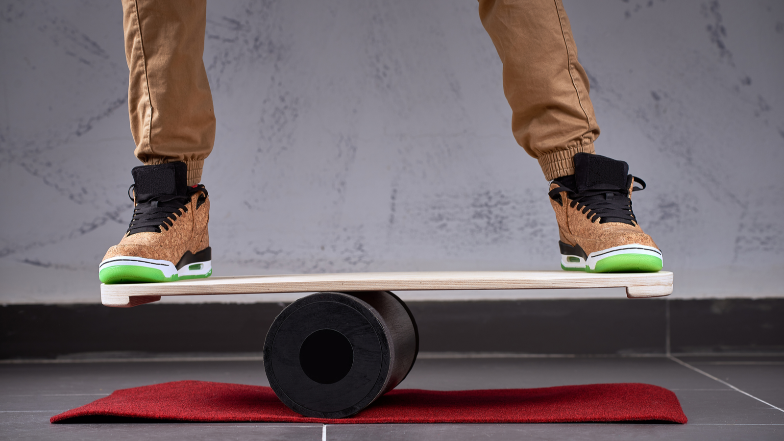 Pont en bois ovale pour planche d'équilibre, rouleau en plastique solide pour planche d'équilibre, personne avec des chaussures de patineur debout et en équilibre sur le pont