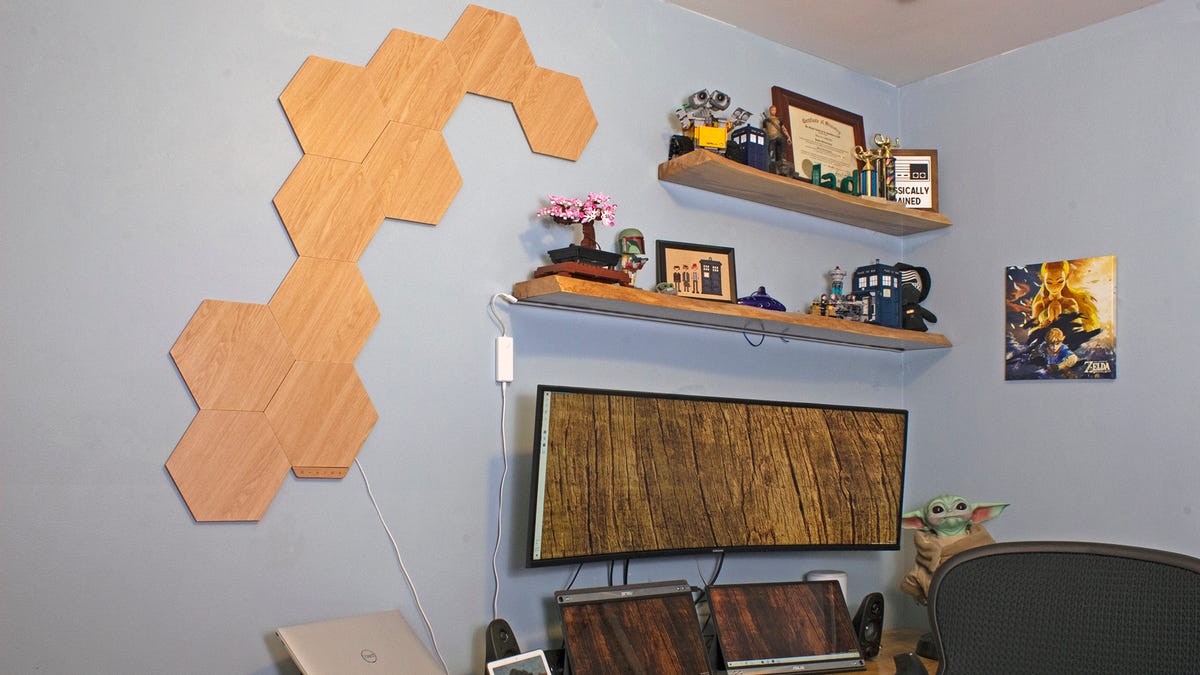 Un bureau entouré de meubles en bois, avec des hexagones en bois sur le mur.