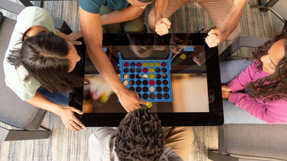 Une table de jeu de société numérique avec'Connect4'sur l'écran