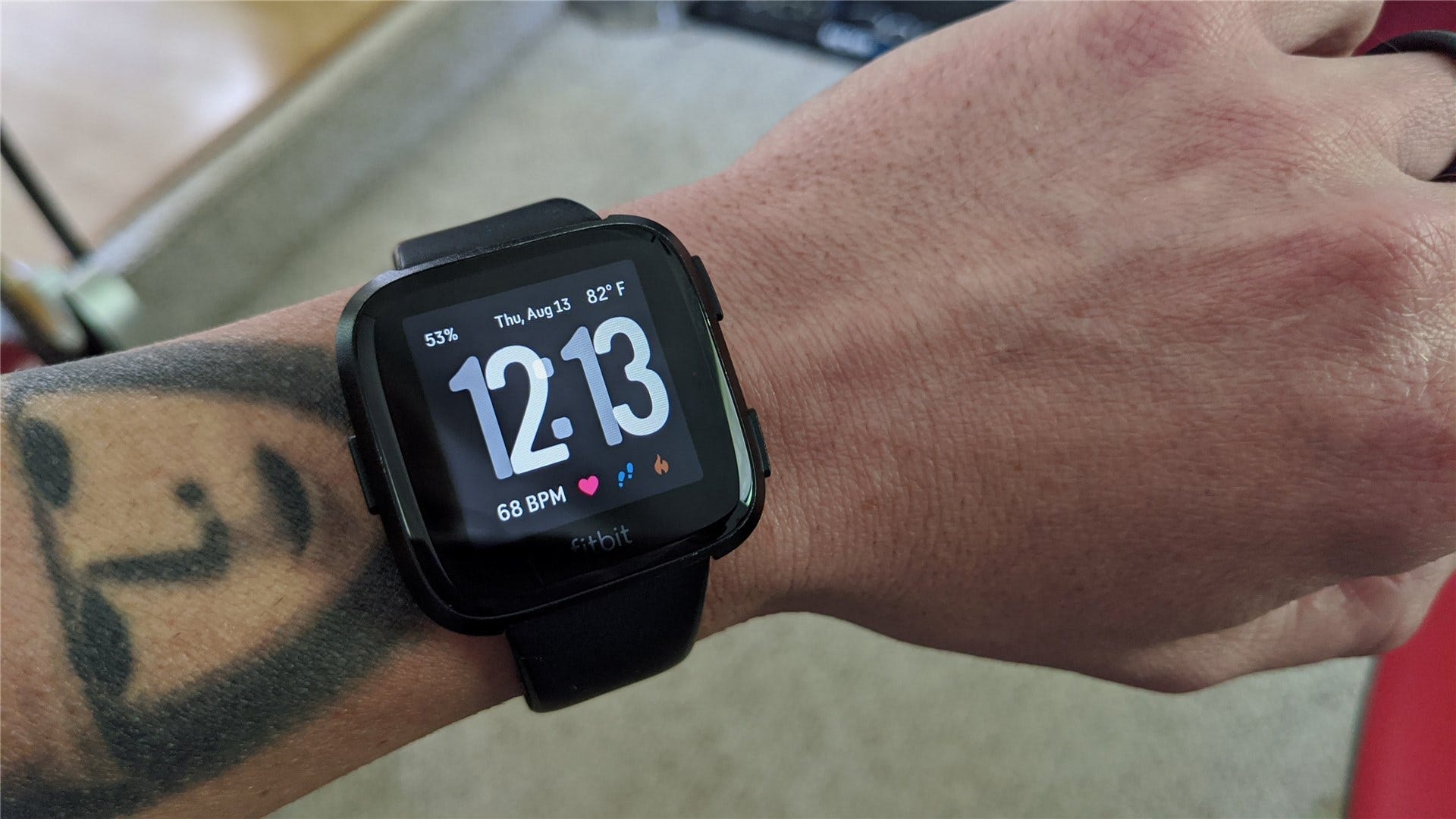 La Fitbit Versa au poignet d'un homme