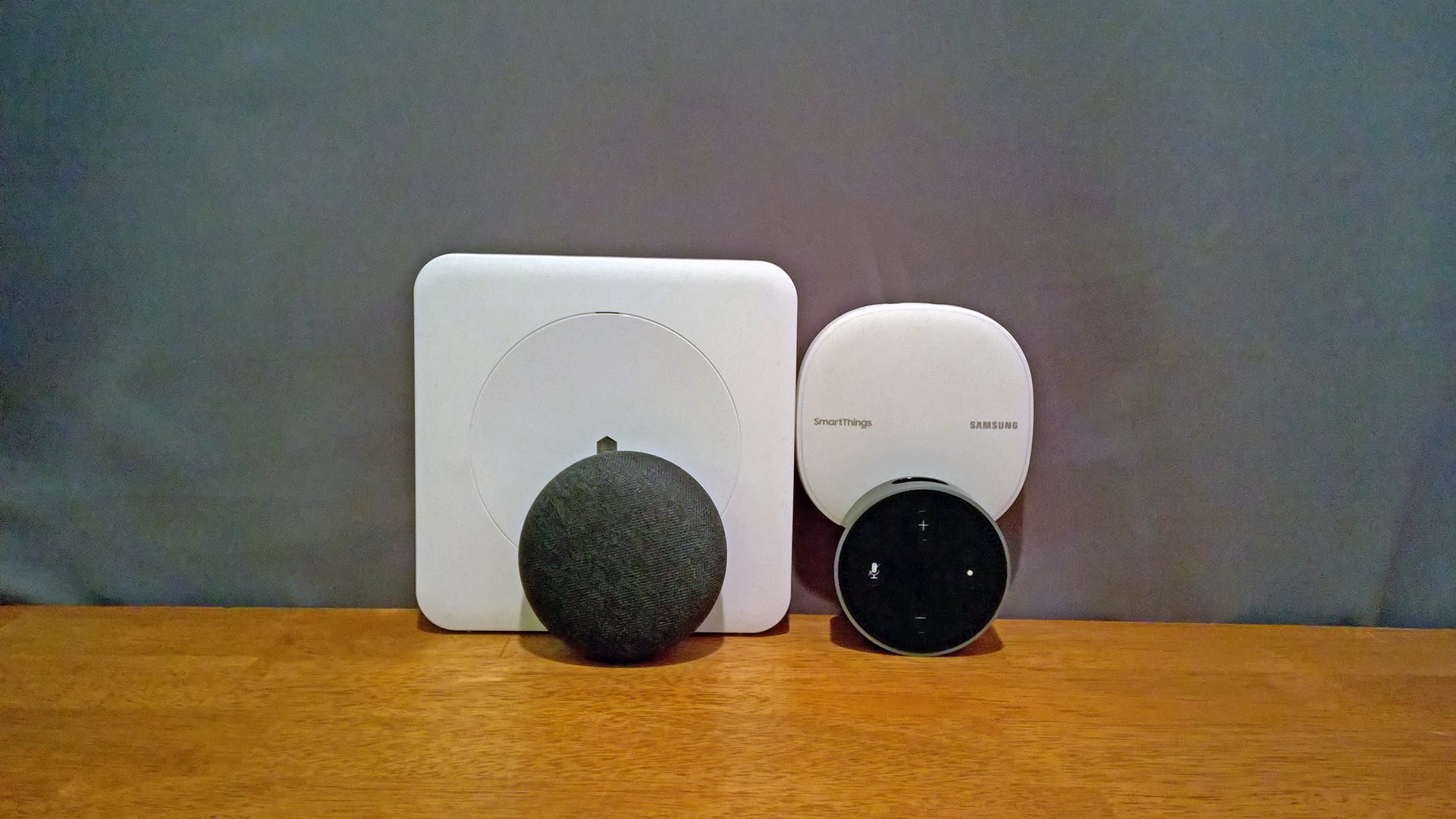 Un punto Nest mini ed Echo davanti a un hub Wink e SmartThings
