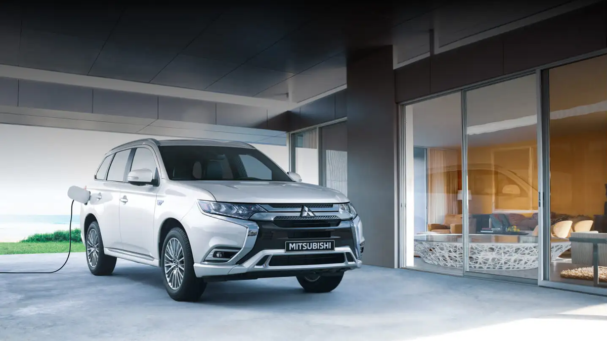 Mitsubishi Outlander wordt opgeladen voor een modern huis