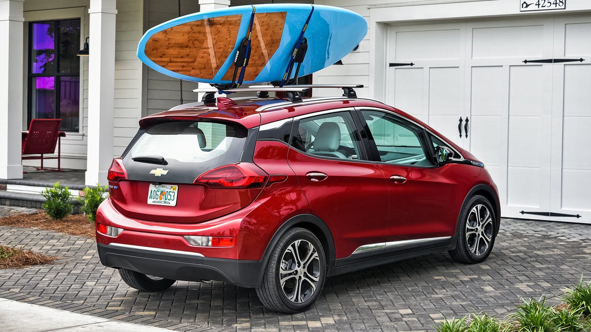 Een Chevrolet Bolt naast een garage.