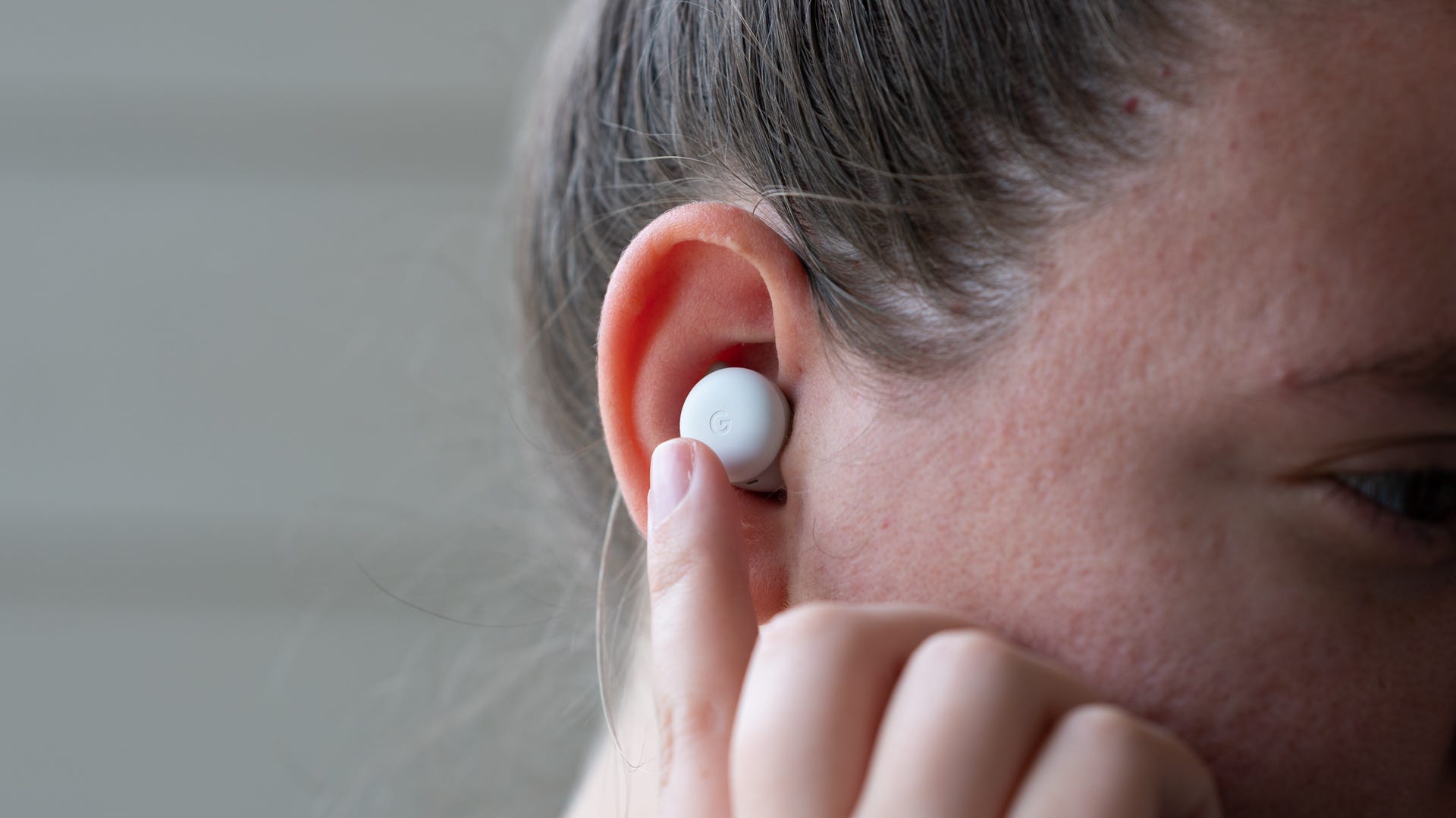 บุคคลที่แตะ Pixel Buds ชุด A ขณะอยู่ในหู