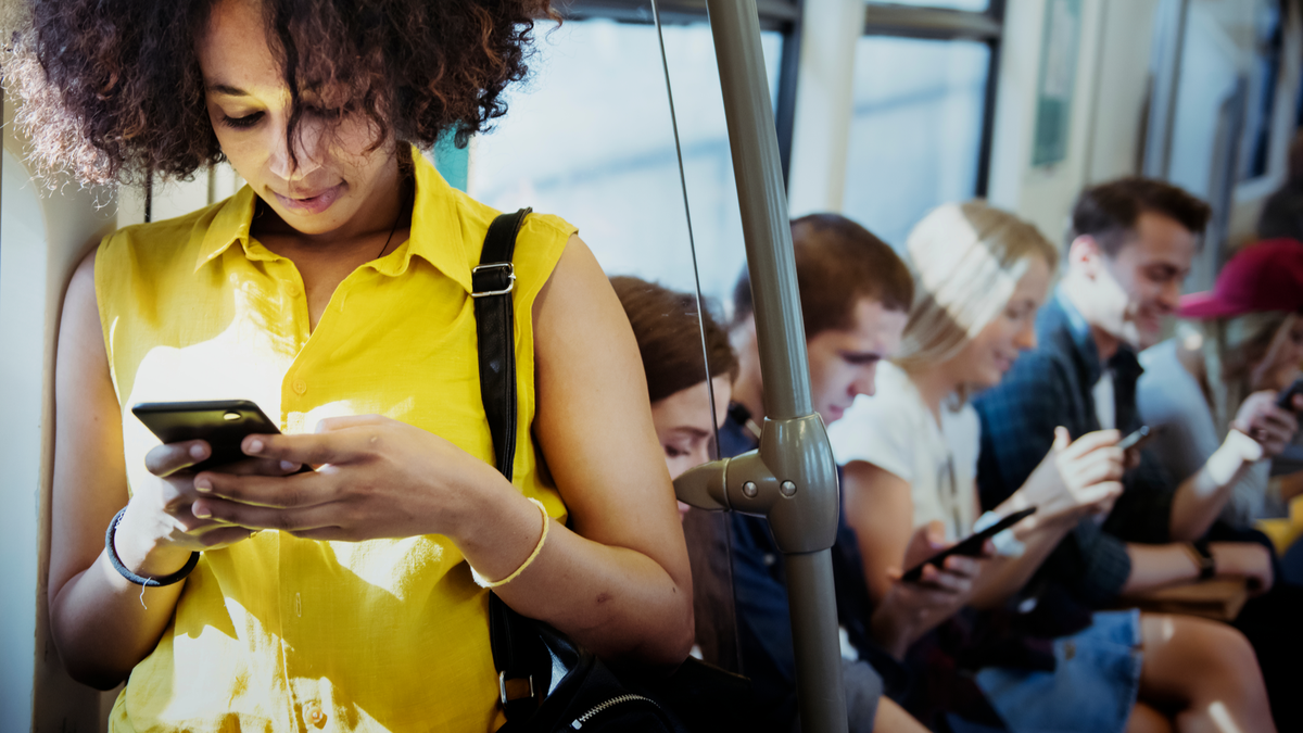 Thanh niên sử dụng điện thoại thông minh trong tàu điện ngầm