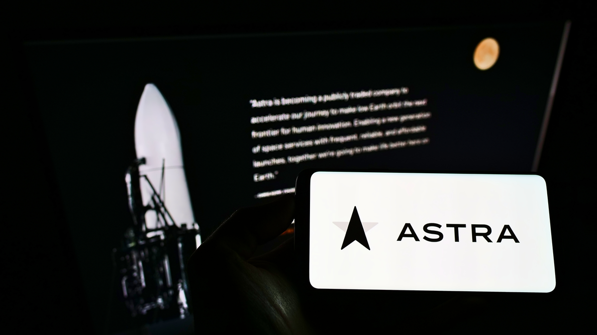 Người cầm điện thoại di động có logo của công ty hàng không vũ trụ Mỹ Astra Space Inc. trên màn hình phía trước trang web