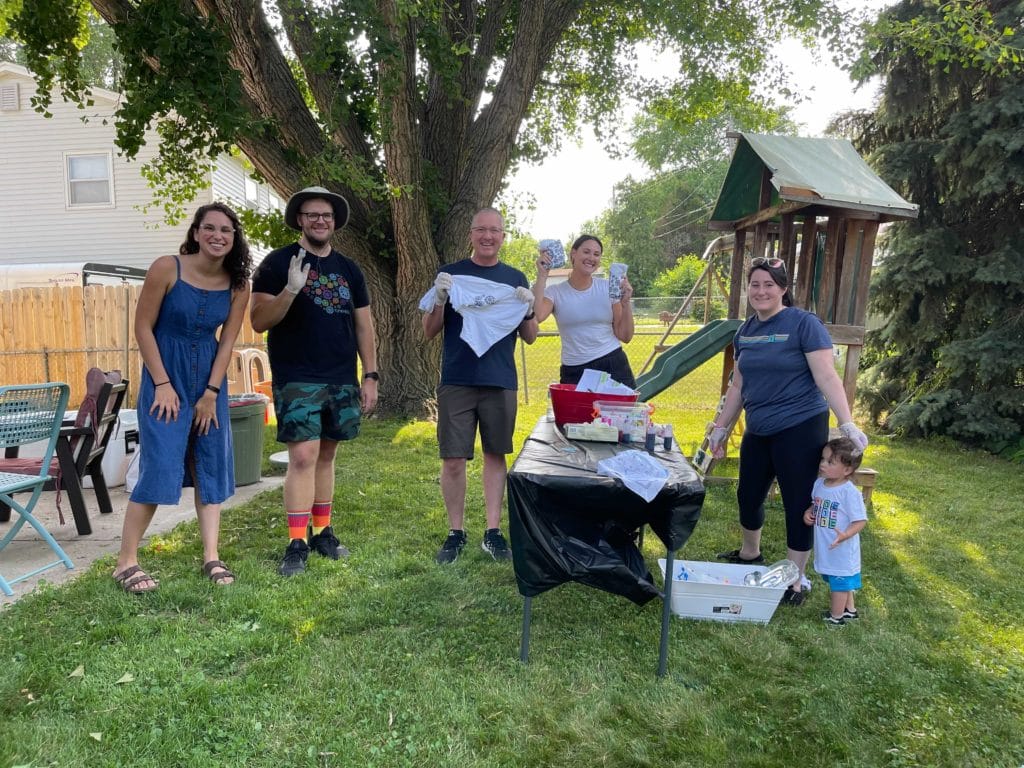 Funcionários de Omaha reunidos em torno de uma mesa usada para tie dying