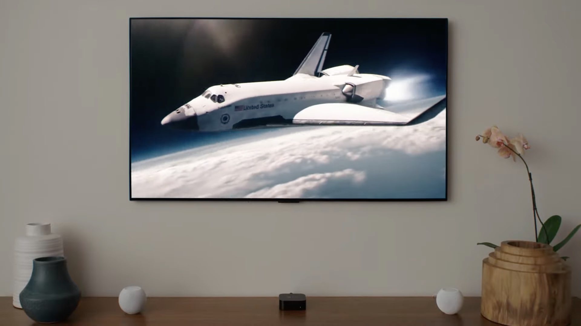Uma imagem mostrando Apple TV 4K e dois minifalantes HomePod na configuração de áudio de home theater